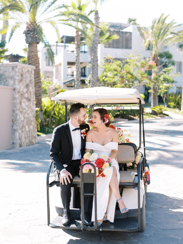 Bride and groom riding on golf cart around resort in Cabo San Lucas
