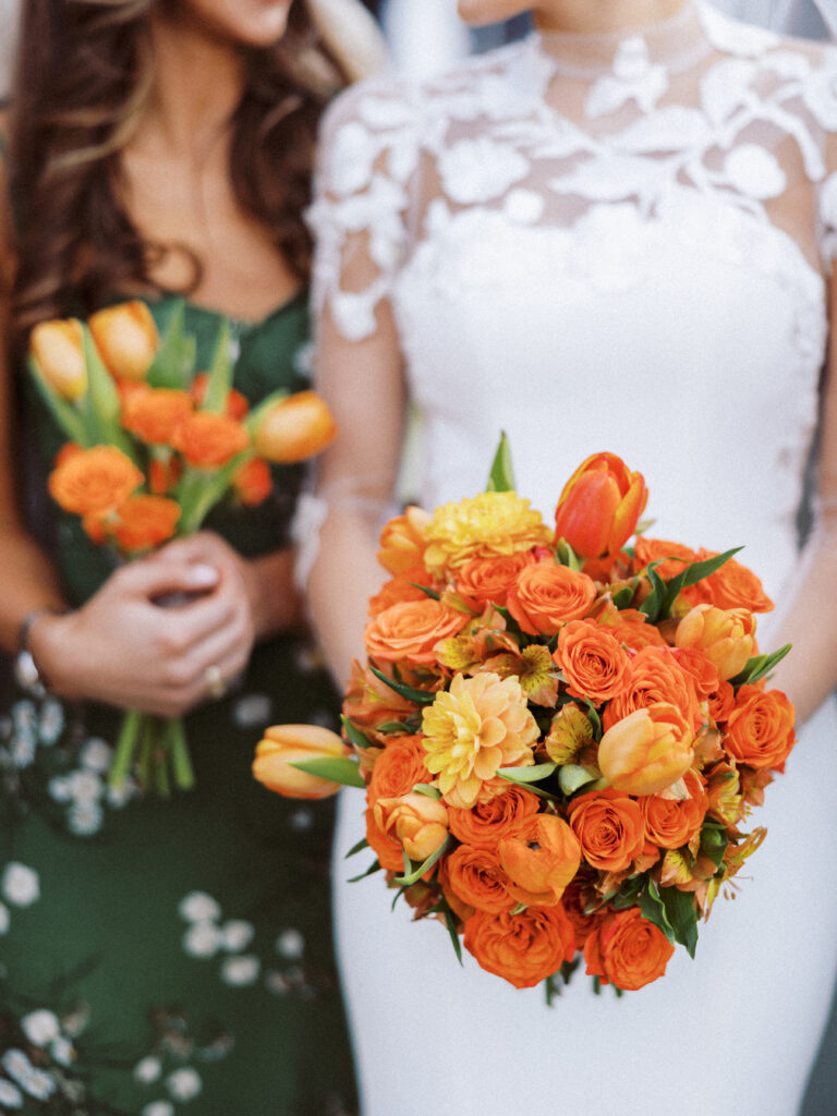 A beautiful bridal bouquet made with bright and vibrant orange flowers and a smaller matching bridesmaid bouquet 