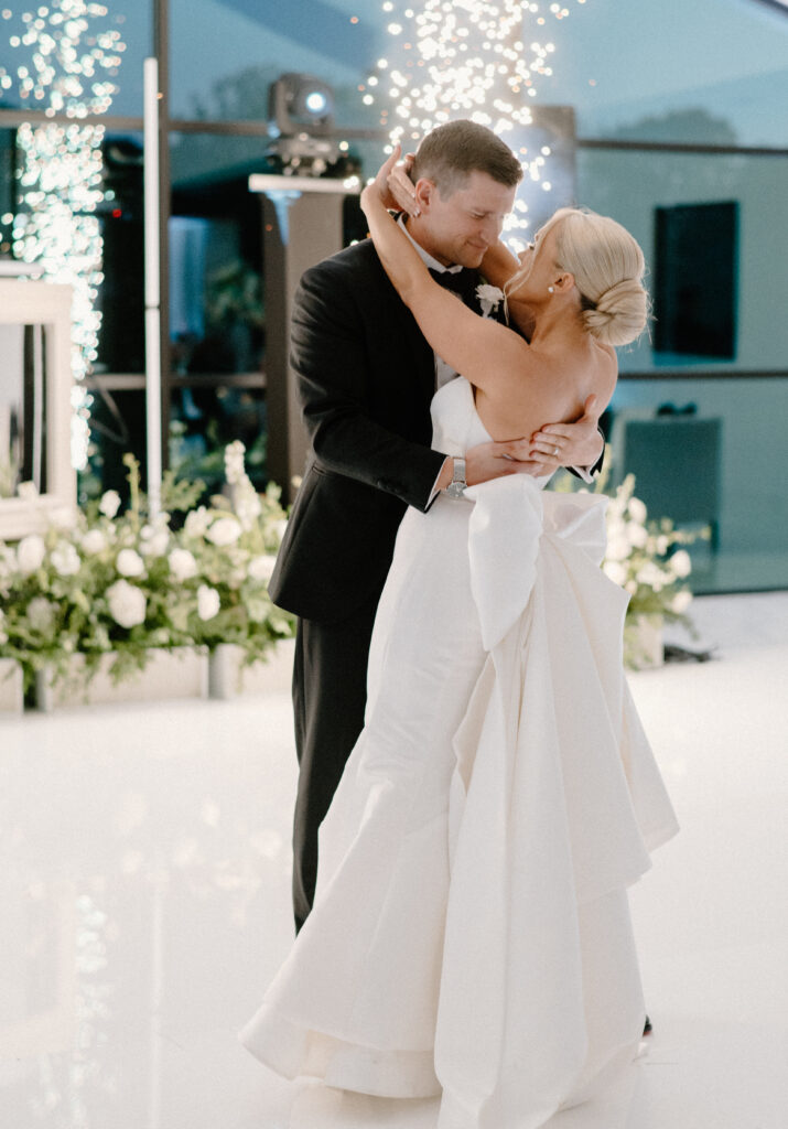 Bride and groom's first dance at wedding reception complete with sparklers and stage florals