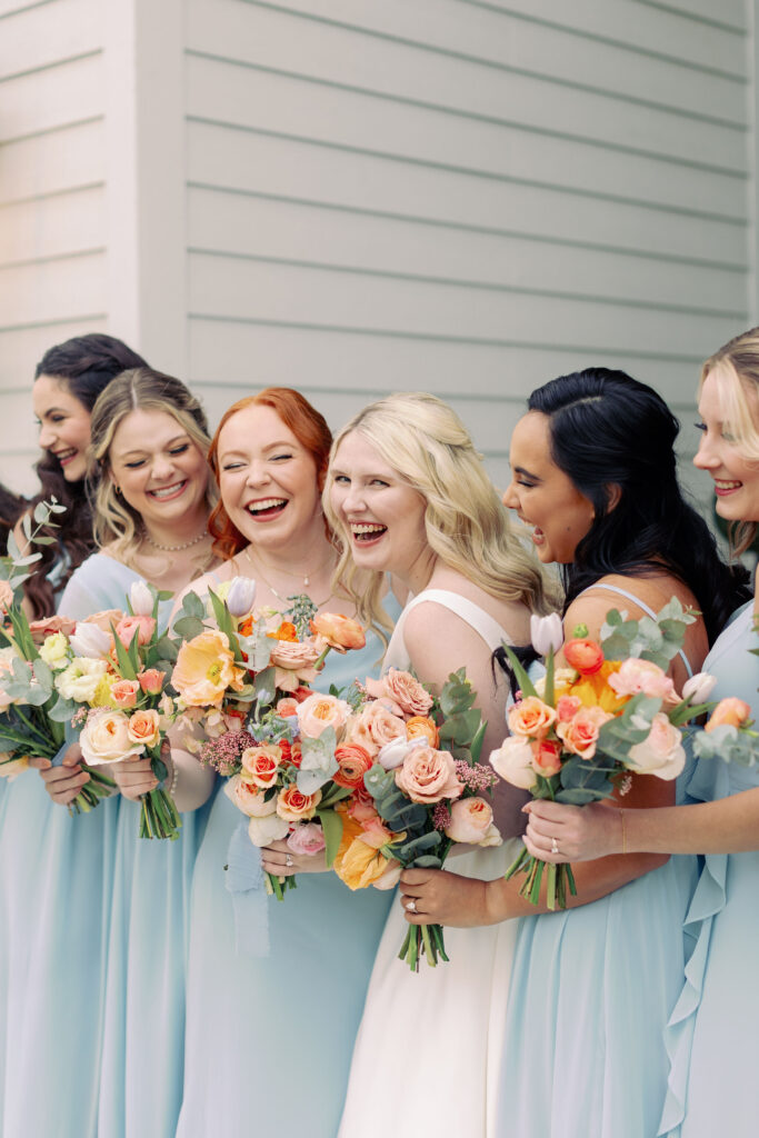 Bride and bridesmaids posing with their colorful bouquets for a spring wedding