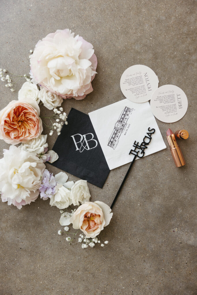 Flat lay details for modern wedding featuring pastel colored flowers
