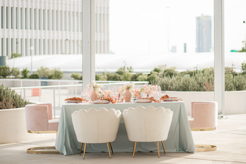An elegant bridal brunch for the bride and her bridesmaids with dainty pastel colored flowers, pink glassware, and blue linens
