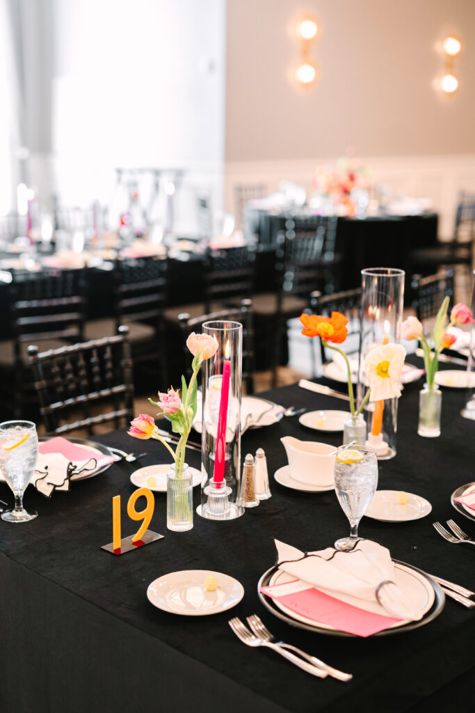 Classic black table linens with pops of colorful flowers and taper candles 