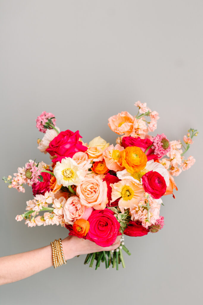 A colorful bridal bouquet filled with bright orange and pink flowers